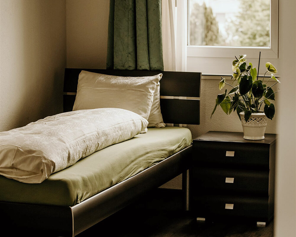 Blick in ein Zimmer mit Bett